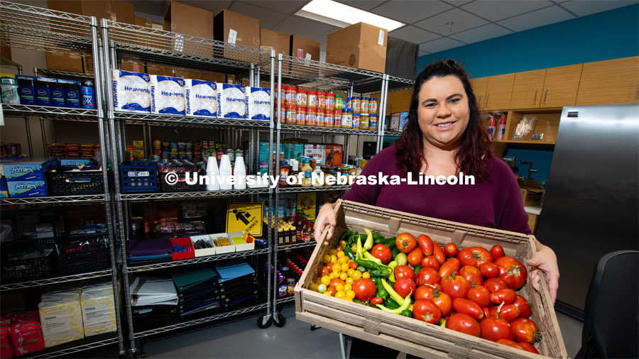 Morgan Smith, a graduate research assistant, shows a tote of fresh vegetables available at Husker Pantry. The pantry and Money Management Center have moved from the Nebraska Union to the University Health Center. August 8, 2019, Photo by Gregory Nathan / University Communication.